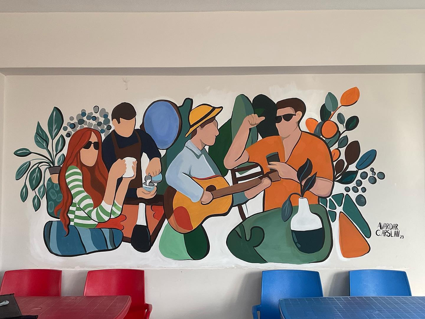 Interior mural with figures among plants by Azra Vardar.